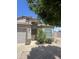 Charming front entry with a large, decorative wood front door, desert landscaping, and a covered walkway to the driveway at 1043 N 90Th Cir, Mesa, AZ 85207
