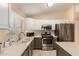 Bright kitchen featuring stainless steel appliances, ample counter space, and modern fixtures for culinary enthusiasts at 1043 N 90Th Cir, Mesa, AZ 85207