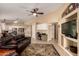 Bright and open living room featuring tile floors, ceiling fan, a TV, and a kitchen view, perfect for entertaining at 1043 N 90Th Cir, Mesa, AZ 85207