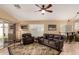 Comfortable living room with plush leather seating, a ceiling fan, tile flooring and a sliding glass door to the backyard at 1043 N 90Th Cir, Mesa, AZ 85207