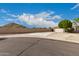 Wide street view of a well-maintained home with a 2-car garage, desert landscaping, and block wall fencing at 1043 N 90Th Cir, Mesa, AZ 85207