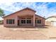 View of the house's back facade highlighting the covered patio and desert landscaping at 11266 E Dartmouth Cir, Mesa, AZ 85207