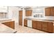 Efficient kitchen with oak cabinetry, white appliances, and a window providing natural light at 11266 E Dartmouth Cir, Mesa, AZ 85207
