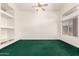 Spacious living room with vaulted ceilings, green carpet, built-in shelves and a large window at 11266 E Dartmouth Cir, Mesa, AZ 85207