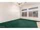 Inviting living room with vaulted ceilings, green carpet, and large windows for natural light at 11266 E Dartmouth Cir, Mesa, AZ 85207