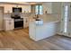 Well-lit kitchen with stainless steel appliances, white cabinets and countertops, and wood-look floors at 1301 N 44Th St, Phoenix, AZ 85008