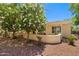Rear exterior showing a covered patio and mature landscaping, offering privacy and shade to the property at 13134 W Los Bancos Ct, Sun City West, AZ 85375