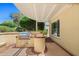 Exterior view of a covered patio with a built-in barbecue and well-maintained landscaping at 13134 W Los Bancos Ct, Sun City West, AZ 85375