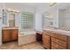 Bathroom featuring double vanities, soaking tub, and glass block window for natural light at 13134 W Los Bancos Ct, Sun City West, AZ 85375