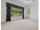Well-lit bedroom with neutral carpet, large window, and access to an outdoor patio area at 13134 W Los Bancos Ct, Sun City West, AZ 85375