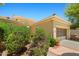 Tan home featuring desert landscaping, a tile roof and a two car garage at 13134 W Los Bancos Ct, Sun City West, AZ 85375