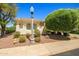 Single-story home with desert landscaping, a vintage street lamp, and a view of the arched windows at 13134 W Los Bancos Ct, Sun City West, AZ 85375