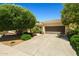 Single-story home featuring a well-manicured lawn, mature trees, and a driveway leading to the garage at 13134 W Los Bancos Ct, Sun City West, AZ 85375