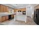Well-lit kitchen features wood cabinetry and a practical center island at 13134 W Los Bancos Ct, Sun City West, AZ 85375