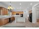 Kitchen with wood cabinets, a center island, and black appliances at 13134 W Los Bancos Ct, Sun City West, AZ 85375