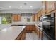 Kitchen with wood cabinets, an island, and updated appliances next to the sink at 13134 W Los Bancos Ct, Sun City West, AZ 85375
