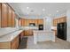 Bright kitchen with light wood cabinetry, an island, and black appliances at 13134 W Los Bancos Ct, Sun City West, AZ 85375
