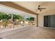 Charming outdoor patio with a built-in barbecue, ceiling fan, and a serene view of the landscaped yard at 13134 W Los Bancos Ct, Sun City West, AZ 85375