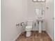 Well-lit powder room featuring modern fixtures, pedestal sink, and tiled flooring at 13134 W Los Bancos Ct, Sun City West, AZ 85375