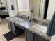 Bathroom featuring double granite vanity, tiled floors, large mirror, and natural light for a clean and bright space at 1314 S Larkspur St, Gilbert, AZ 85296