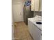 Well-equipped laundry room with washer, dryer, refrigerator, cabinets, and tiled floor for easy cleaning at 1314 S Larkspur St, Gilbert, AZ 85296