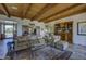 Open living room with wood beam ceiling, comfortable seating, and access to other areas of the home at 1401 E Boulder Pass Pass, Carefree, AZ 85377