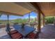 Covered outdoor patio with comfortable seating and dining set, providing a perfect spot for relaxation and enjoying the desert landscape at 1401 E Boulder Pass Pass, Carefree, AZ 85377