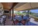 Covered outdoor patio with a stone floor, featuring a dining table and chairs for outdoor dining and relaxation at 1401 E Boulder Pass Pass, Carefree, AZ 85377
