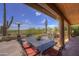 Spacious covered patio with stone flooring and desert views, offering a relaxing outdoor experience with outdoor dining at 1401 E Boulder Pass Pass, Carefree, AZ 85377