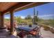 Relaxing covered patio features stone flooring and comfortable seating, creating an inviting outdoor space with beautiful desert views at 1401 E Boulder Pass Pass, Carefree, AZ 85377