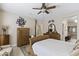 Bedroom with ceiling fan, tile floors, and ensuite bathroom and closet entrance at 15797 W Cinnabar Dr, Surprise, AZ 85374