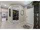 Inviting entryway featuring tile flooring, a decorative mirror, and views of the office and living spaces at 15797 W Cinnabar Dr, Surprise, AZ 85374