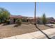 Inviting single-story home featuring a red tile roof, desert landscaping, and a well-manicured front yard with mature trees at 15797 W Cinnabar Dr, Surprise, AZ 85374