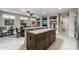 Open-concept kitchen with tile flooring, center island, and views of the dining area at 15797 W Cinnabar Dr, Surprise, AZ 85374
