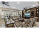 Cozy living room with a built-in entertainment center, plantation shutters, and comfortable seating at 15797 W Cinnabar Dr, Surprise, AZ 85374