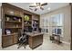 Home office with dark wood built-ins, a desk, and natural light from shuttered windows creating a professional workspace at 15797 W Cinnabar Dr, Surprise, AZ 85374