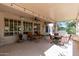 Covered patio with tan walls, ceiling fan, and comfortable seating area, offering an ideal outdoor relaxation space at 15797 W Cinnabar Dr, Surprise, AZ 85374
