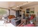 Inviting covered patio features a cozy seating area with a stylish fire pit, perfect for outdoor entertaining and relaxation at 15797 W Cinnabar Dr, Surprise, AZ 85374