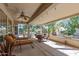 Spacious covered patio boasts lounge chairs, dining set, and views of palm trees, perfect for outdoor living and relaxation at 15797 W Cinnabar Dr, Surprise, AZ 85374