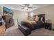 A cozy bedroom with dark wood furnishings, a bench, and a mounted television at 15812 W Lisbon Ln, Surprise, AZ 85379