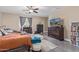 Spacious main bedroom featuring a ceiling fan, dresser, television and natural light at 15812 W Lisbon Ln, Surprise, AZ 85379