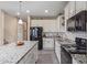 Kitchen showcasing an island with granite countertops, white cabinets, and modern appliances at 15812 W Lisbon Ln, Surprise, AZ 85379