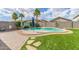 A backyard oasis features a pool surrounded by artificial turf and rock landscaping with a stone walkway and palm trees at 15812 W Lisbon Ln, Surprise, AZ 85379
