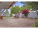 A tiled backyard patio with lush landscaping, a charming shed, and vibrant bougainvillea at 16235 W Cottonwood St, Surprise, AZ 85374