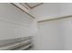 A walk-in closet with white walls, wood floors, and shelving and clothes rods at 16235 W Cottonwood St, Surprise, AZ 85374