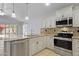 Bright kitchen with stainless steel appliances, granite counters, and stylish pendant lighting at 16235 W Cottonwood St, Surprise, AZ 85374