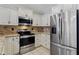Kitchen boasts stainless steel appliances, granite countertops, and custom white cabinetry at 16235 W Cottonwood St, Surprise, AZ 85374
