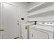 A laundry room featuring a side-by-side washer and dryer, and shelving for storage at 16235 W Cottonwood St, Surprise, AZ 85374