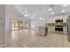 Bright, open-concept kitchen and living area with tile flooring, stainless steel appliances, and access to the backyard at 16235 W Cottonwood St, Surprise, AZ 85374