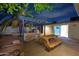 Backyard featuring a covered outdoor kitchen, picnic table, lush greenery, and direct access to interior at 1644 W Roma Ave, Phoenix, AZ 85015